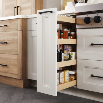 A Dura Supreme Base Pull-Out Pantry neatly stores row after row of pantry goods within a narrow space making it easy to see the entire contents of your pantry at a glance. (Available in wood or wire options). This scandi style kitchen uses the wood shelf option.