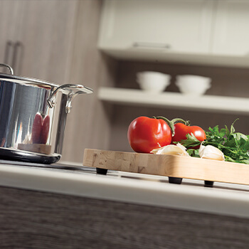 A close-up of the prep zone in a kitchen design. Learn how to optimize your kitchen layout. A kitchen island with a modern cooktop and space to prepare food close by is a great option.