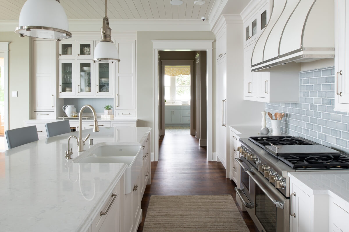 A luxurious all-white kitchen design with bright white painted cabinets from Dura Supreme Cabinetry with inset cabinet cosntruction and a modern farmhouse look.