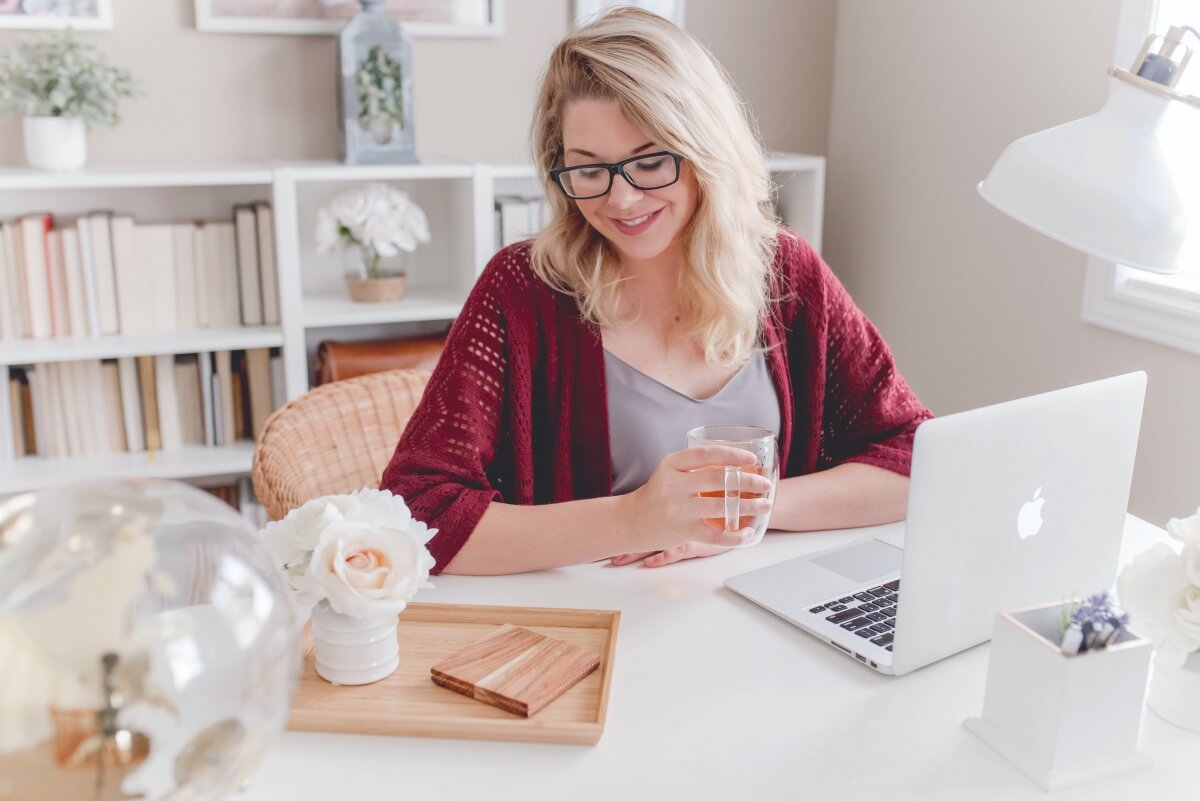 A woman working-from-home in her brightly lit and comfortably styled home office.