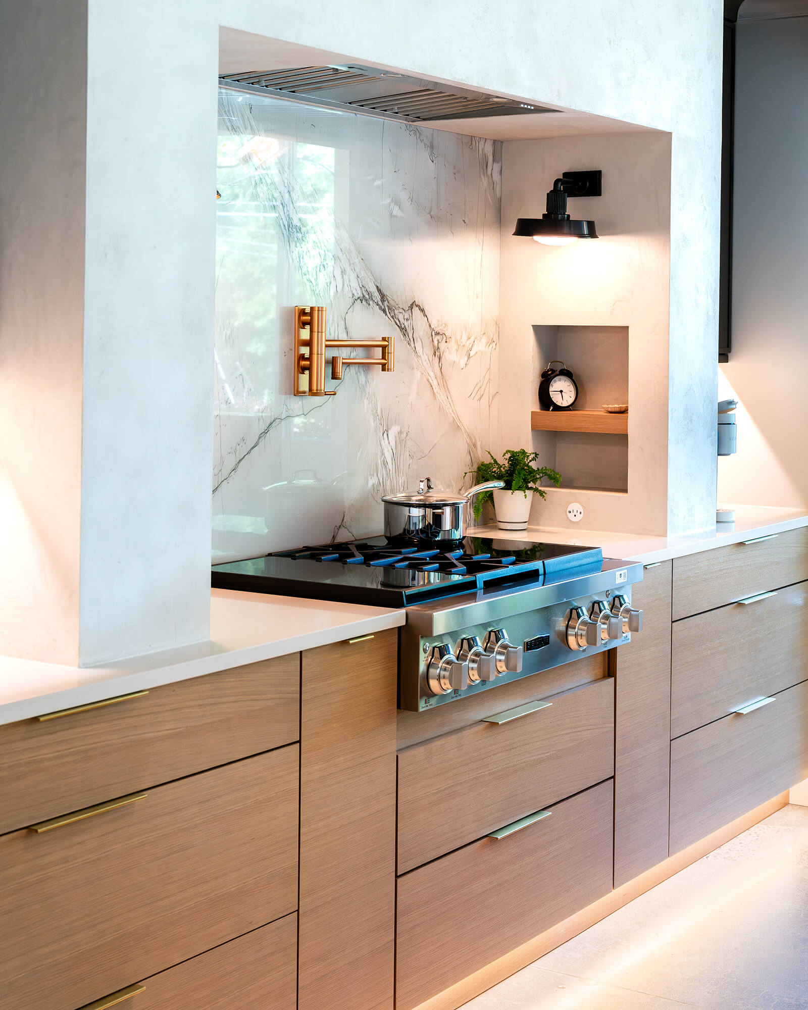 Light stained wood custom kitchen cabinets feature sleek slab doors and a continuous horizontal grain pattern that emphasizes the natural beauty of the wood. Clean lines, integrated storage, and contemporary detailing create a warm, modern kitchen design.