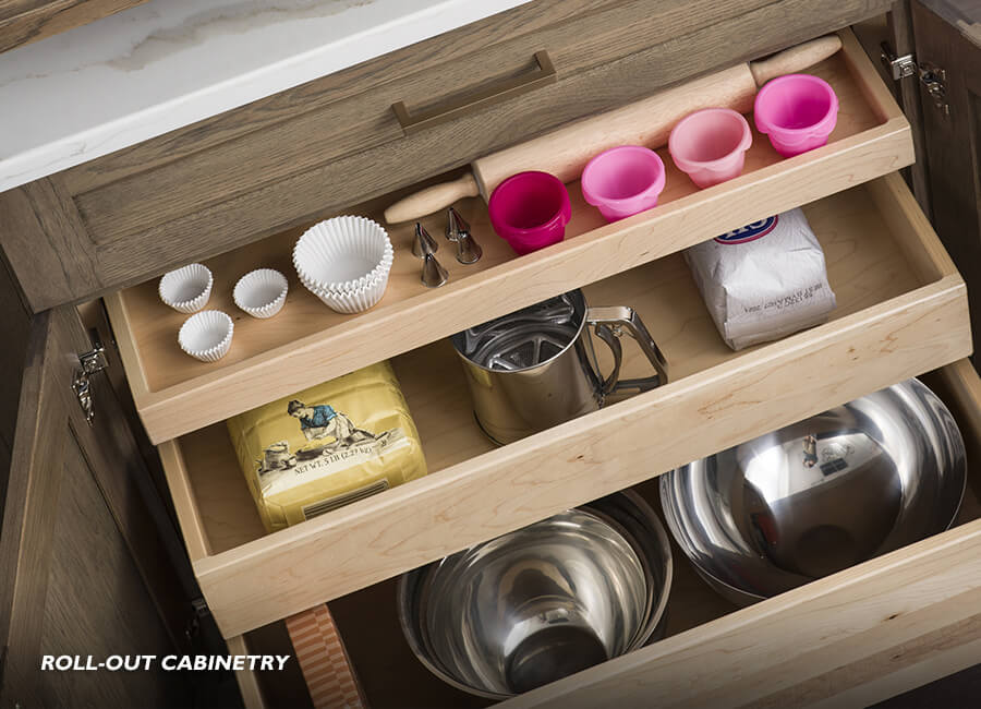 What is Roll-Out kitchen cabinet storage? Roll-out storage is a kitchen cabinet storage accessory that can be “rolled out” after the cabinet door is opened, allowing the user to easily access items stored in the back of a cabinet. Here is an example with multiple sized roll-out shelves within a base cabinet.