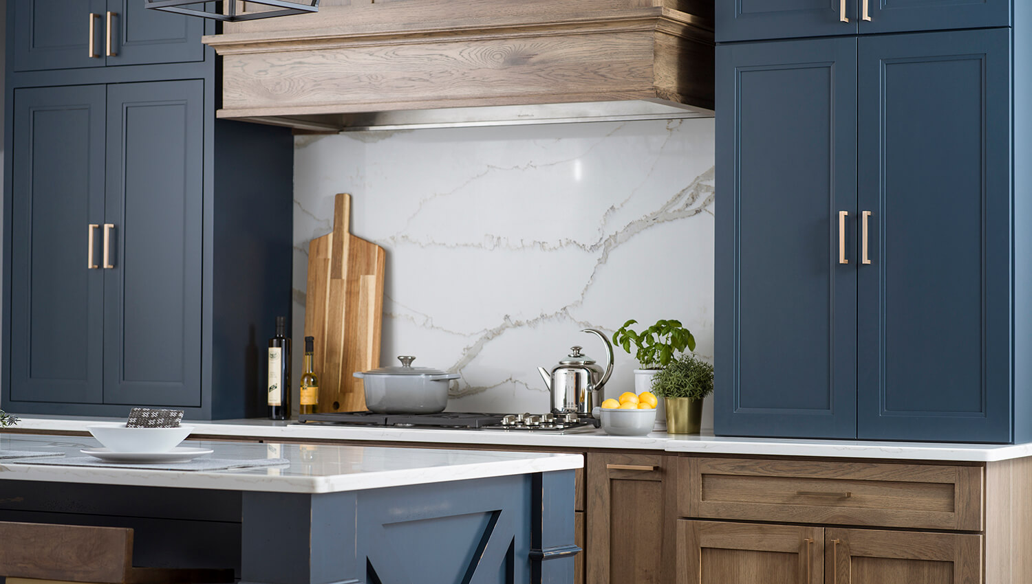 This beautiful modern farmhouse kitchen design features Dura Supreme's popular Morel stain on Hickory contrasted by cabinets featuring our Gale Force blue paint color.