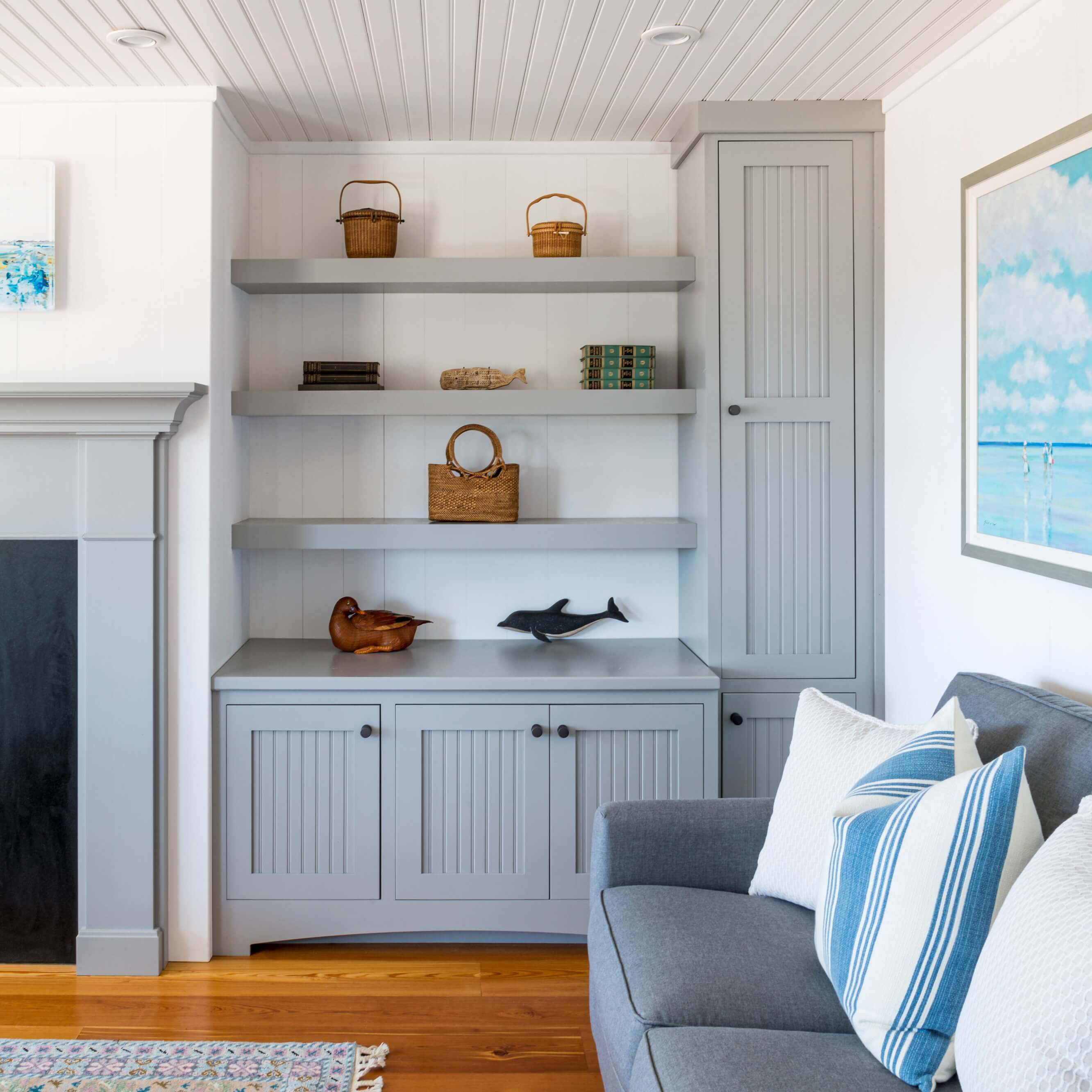 A gray built-in entertainment center and bookcase surrounding and matching the fireplace mantle by Dura Supreme Cabinetry.