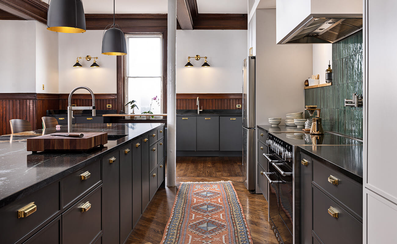 A modern kitchen with a skinny shaker door style in a dark gray/ black painted finish.