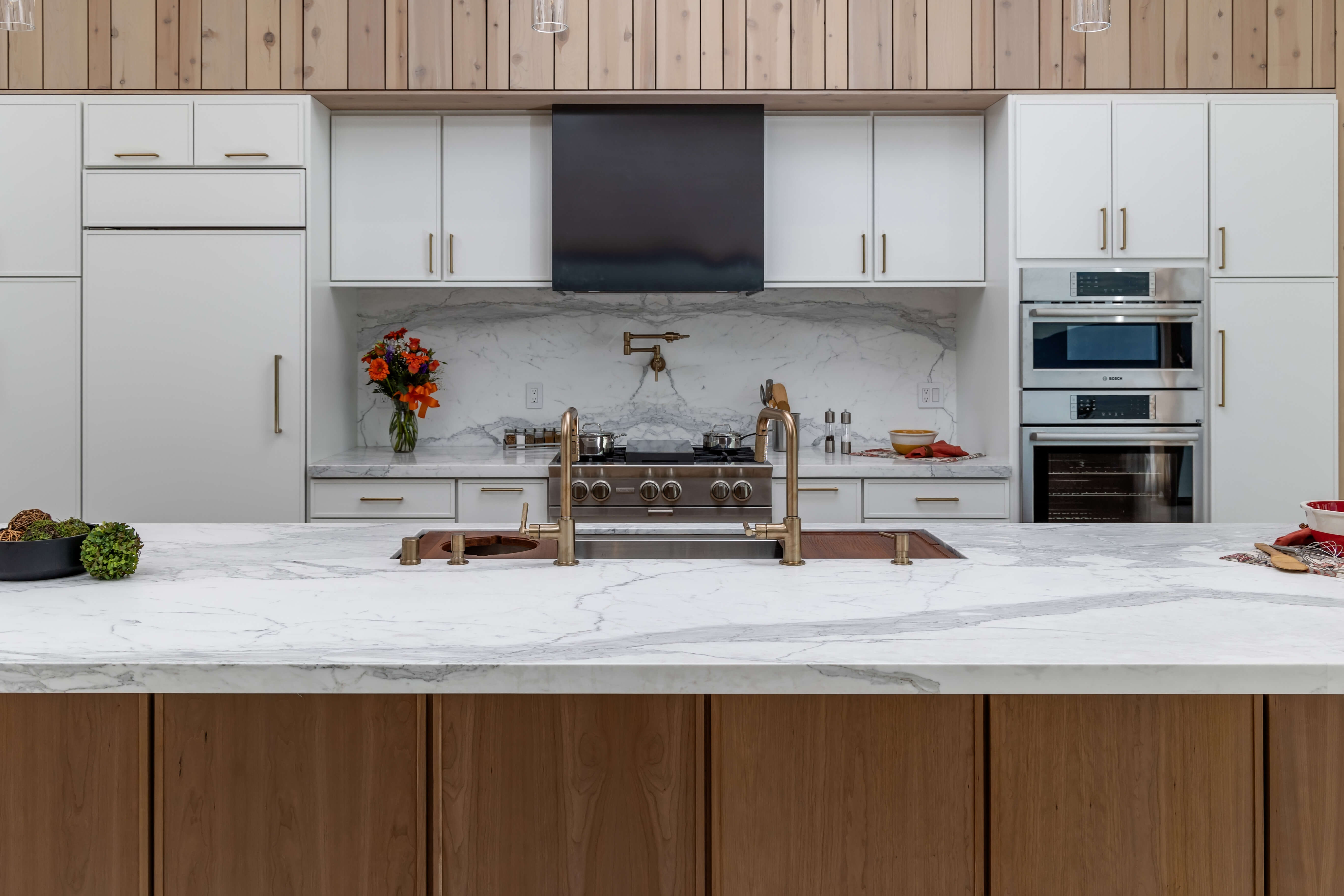 A symmetrical modern kitchen design with a cutting-edge, skinny shaker door style and a warm, cherry wood color palette.