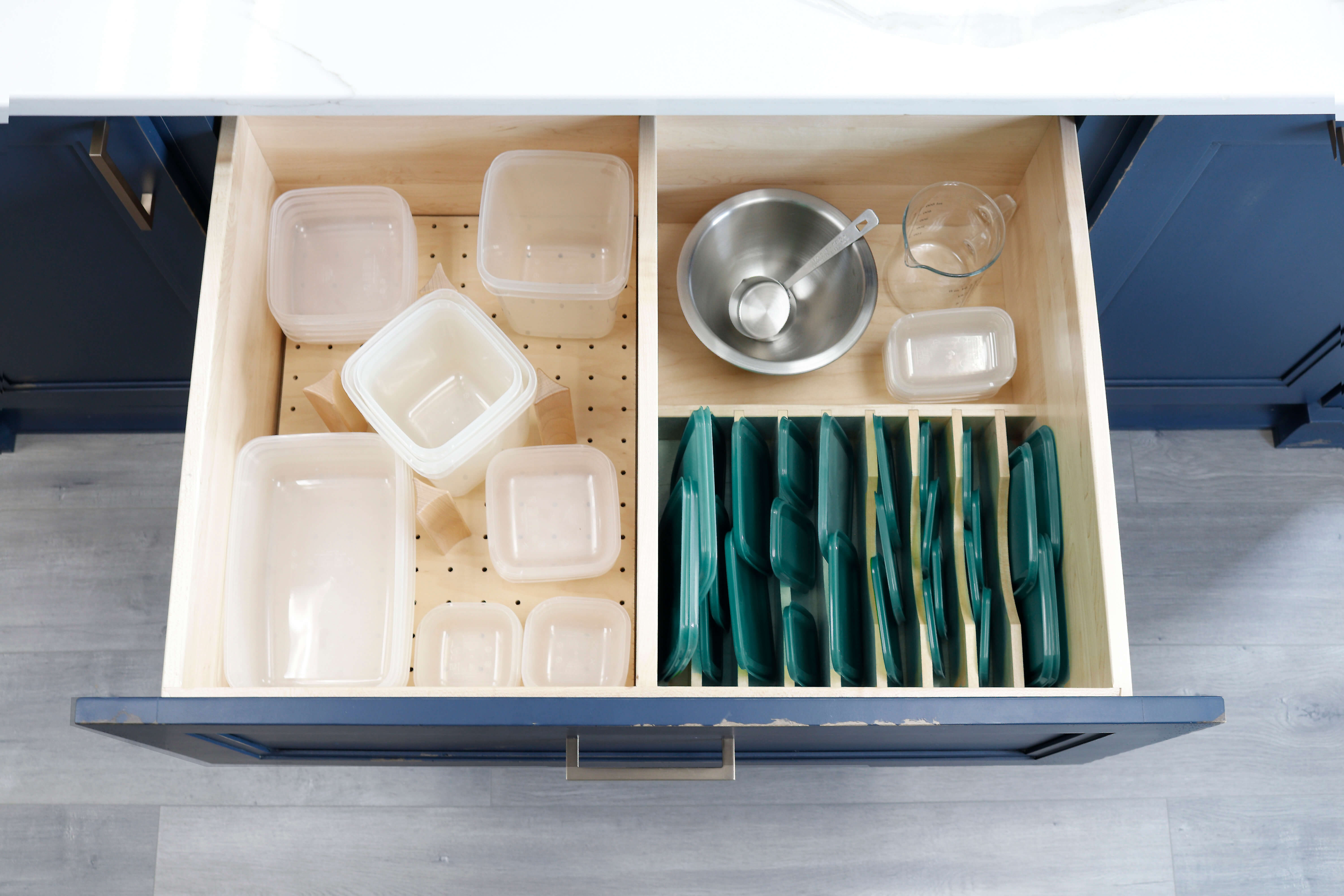 A dish rack drawer used for organizing food containers and lids.