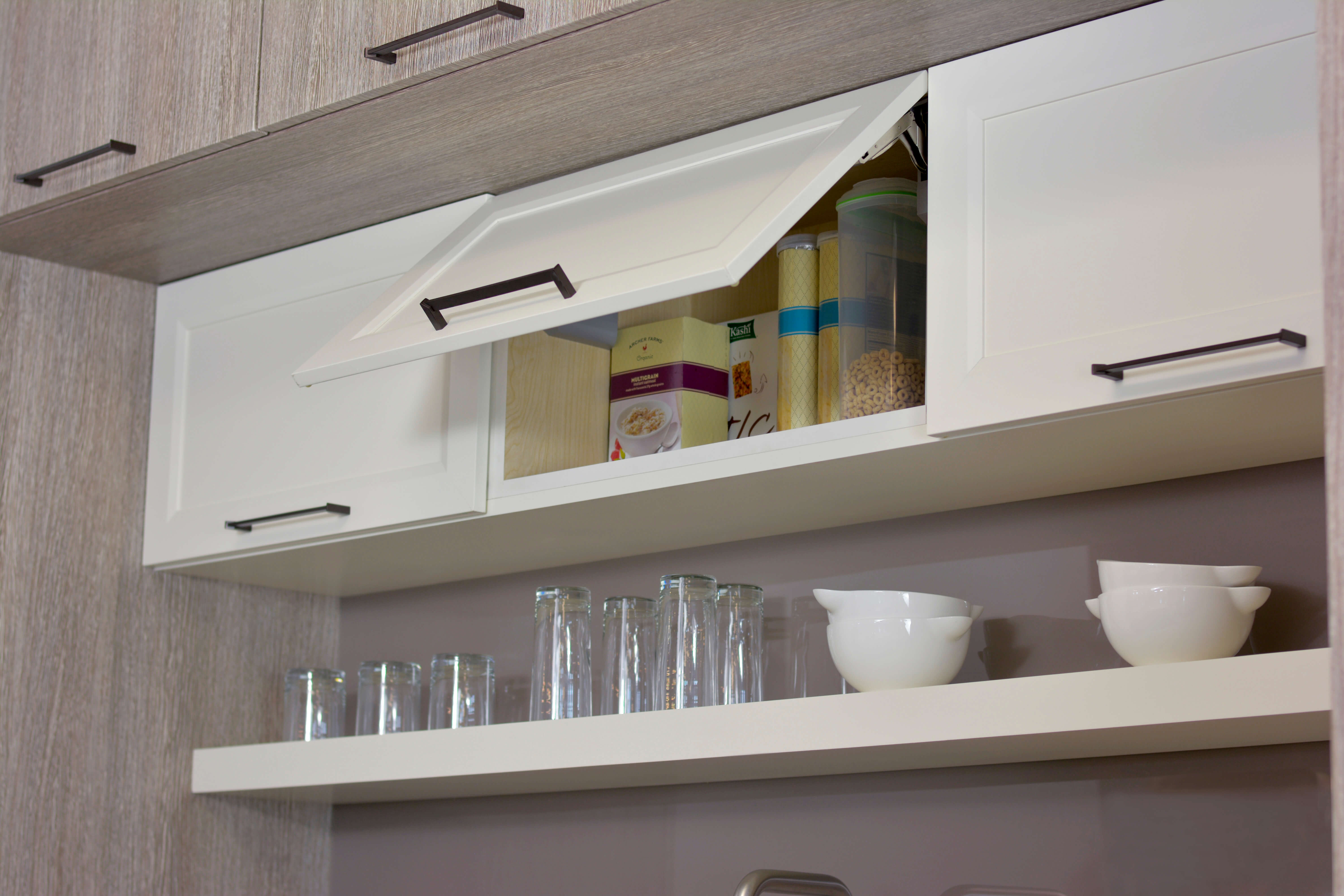 A wall cabinet with a Stay-Lift Cabinet door that holds in place to make it easy to store items in an upper cabinet from Dura Supreme Cabinetry.