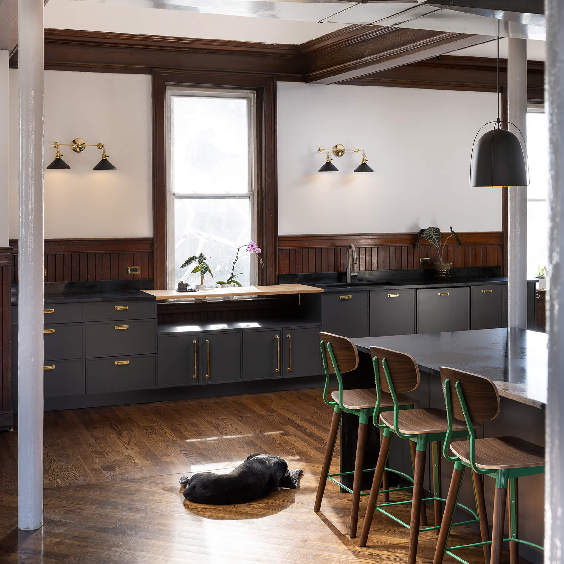 A modern kitchen with black painted cabinets that have a modern shaker cabinet door style.