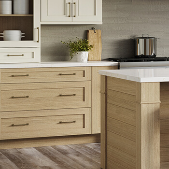 A close up of light stained white oak cabinets and off-white painted cabinets with a shaker style.