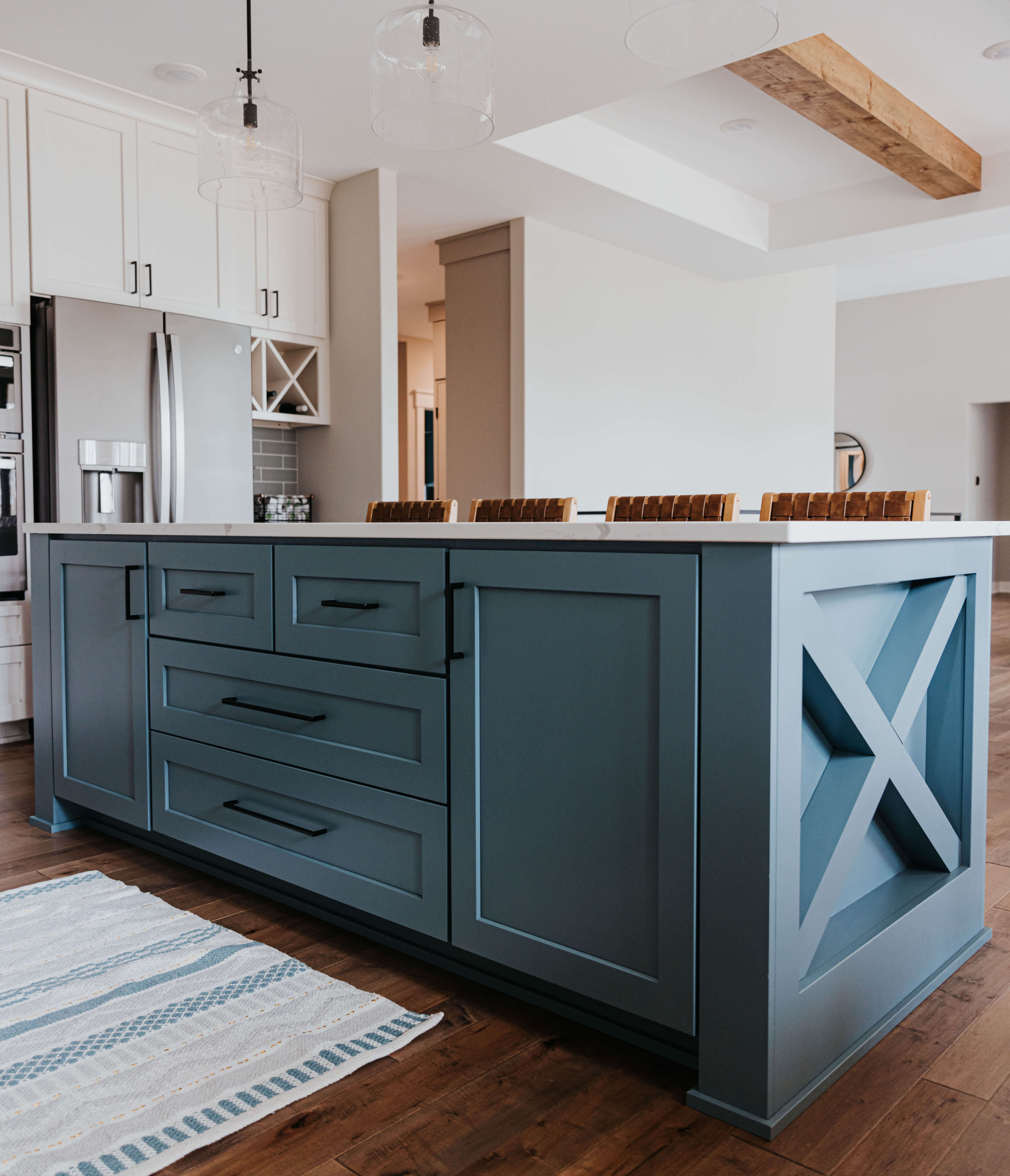 A modern farmhouse kitchen island with a tranquil blue paint color with an X-end cap detail.