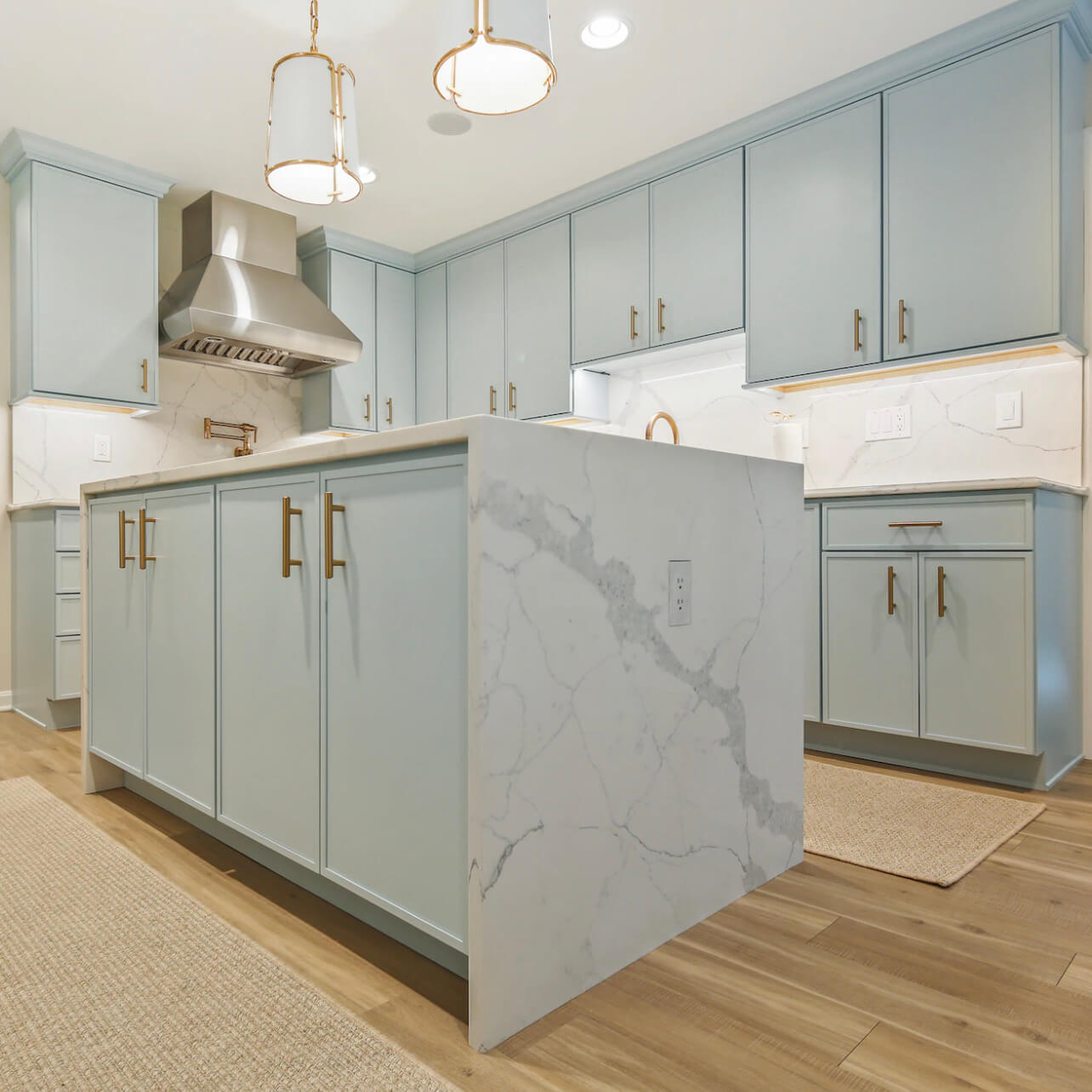 A modern kitchen with a skinny shaker door style in a light, sky blue paint color called Little Boy Blu from Benjamin Moore.