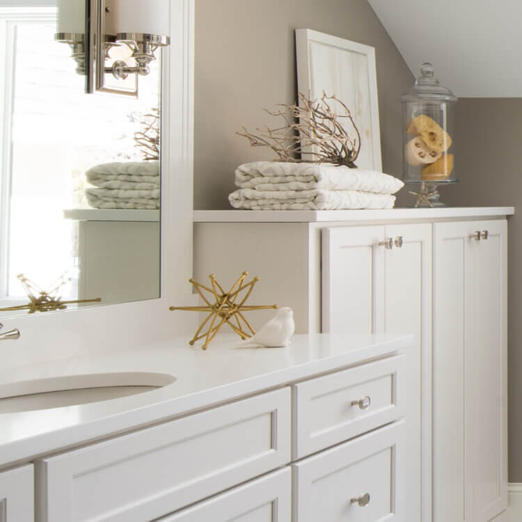 A coastal style master bathroom with white painted cabinets and nautical inspired coastal decor.