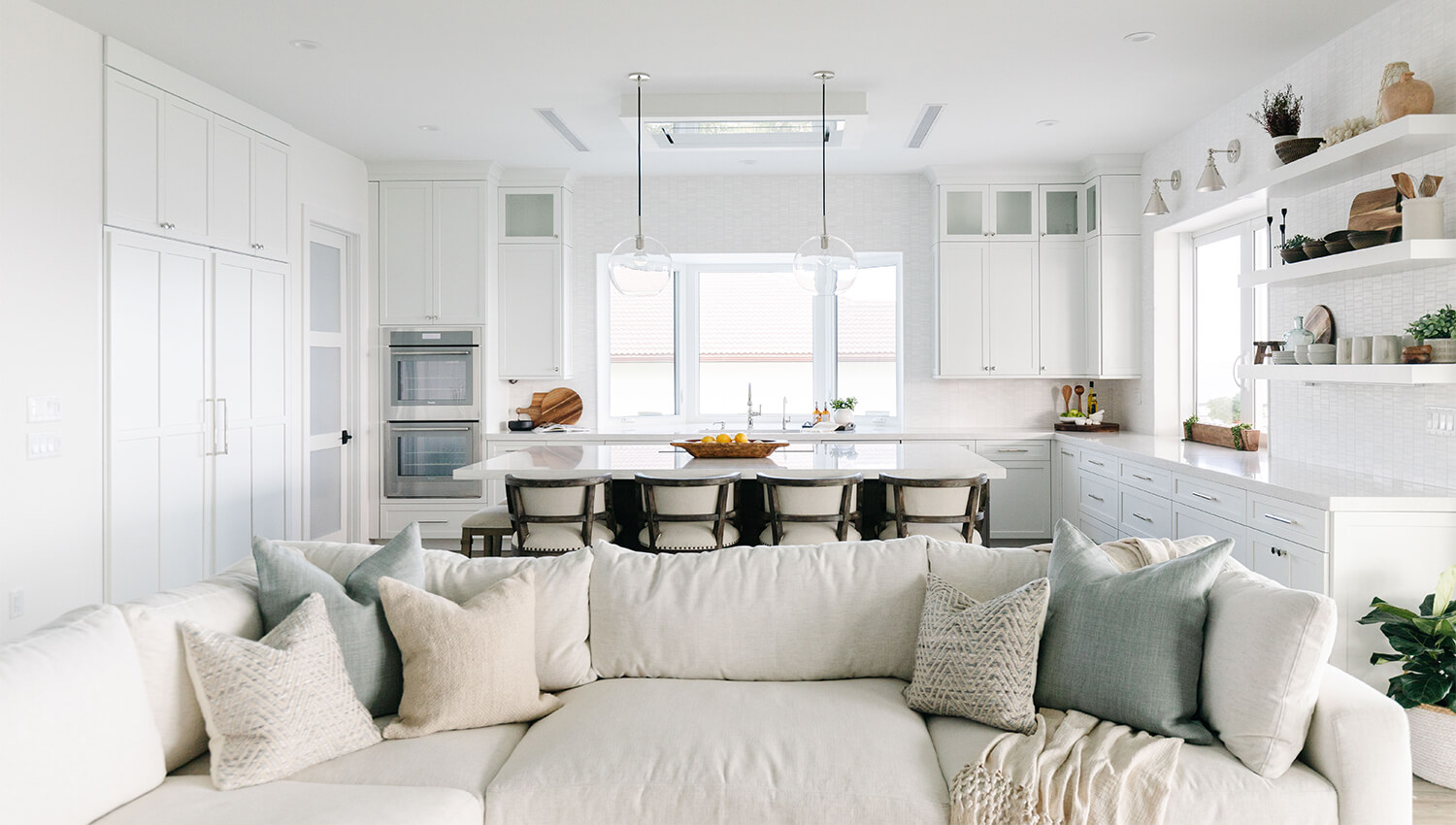A bright and Coastal styled open concept home with a kitchen and living room.