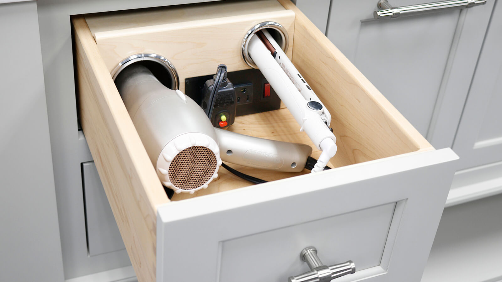 Bathroom cabinet accessory with a vanity grooming drawer for hair dryer and curling iron storage.