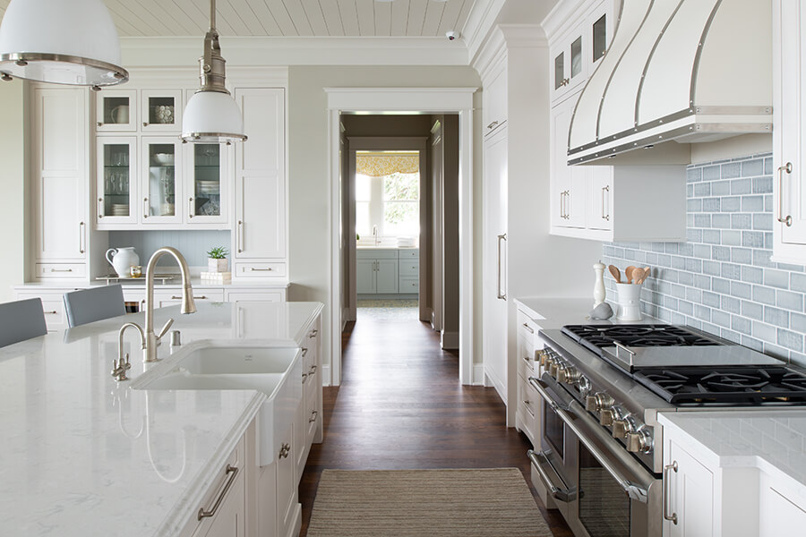 White kitchen cabinets and white countertops in a modern coastal styled kitchen design.