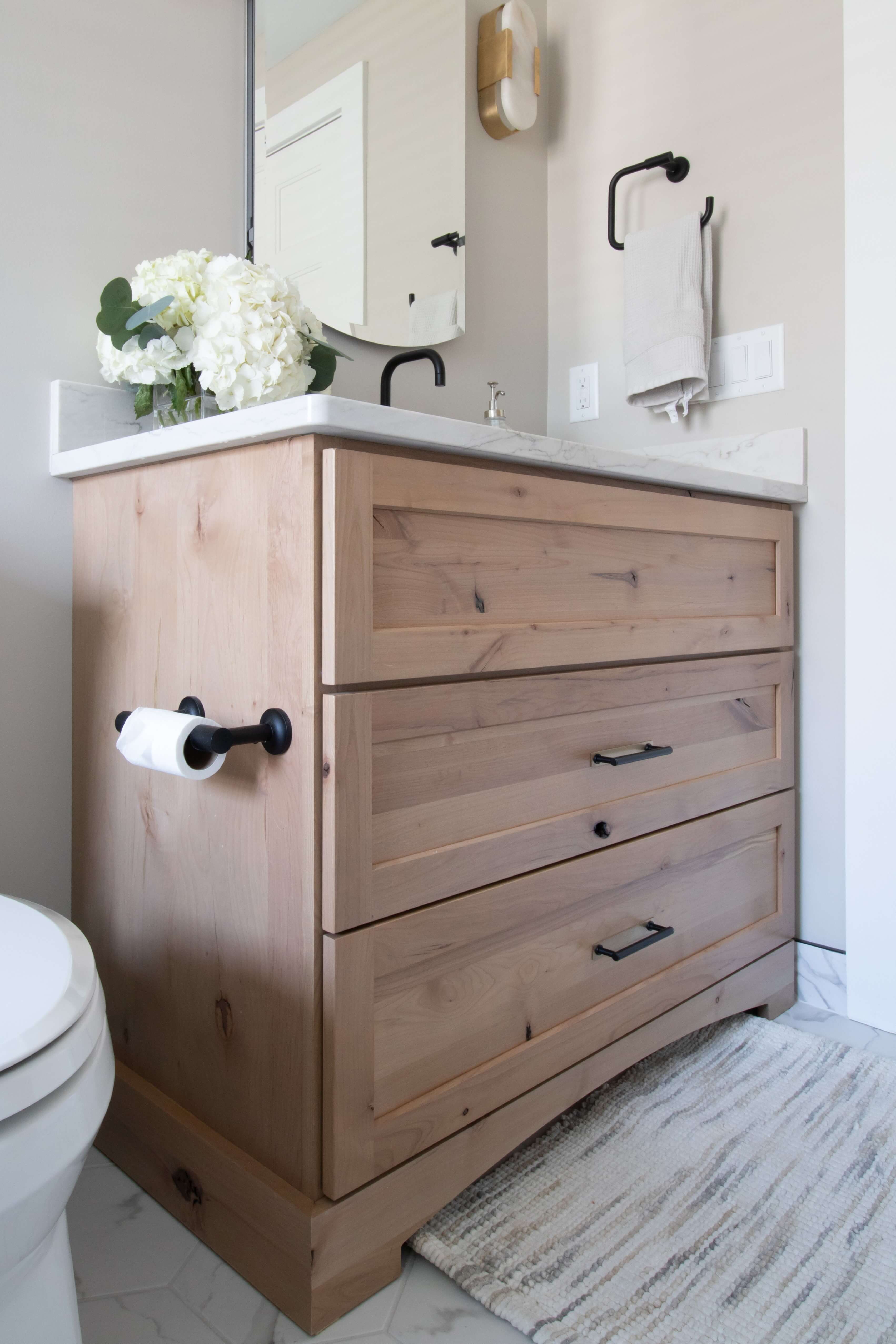 A beautiful furniture styled vanity in a powder room with a rustic look.