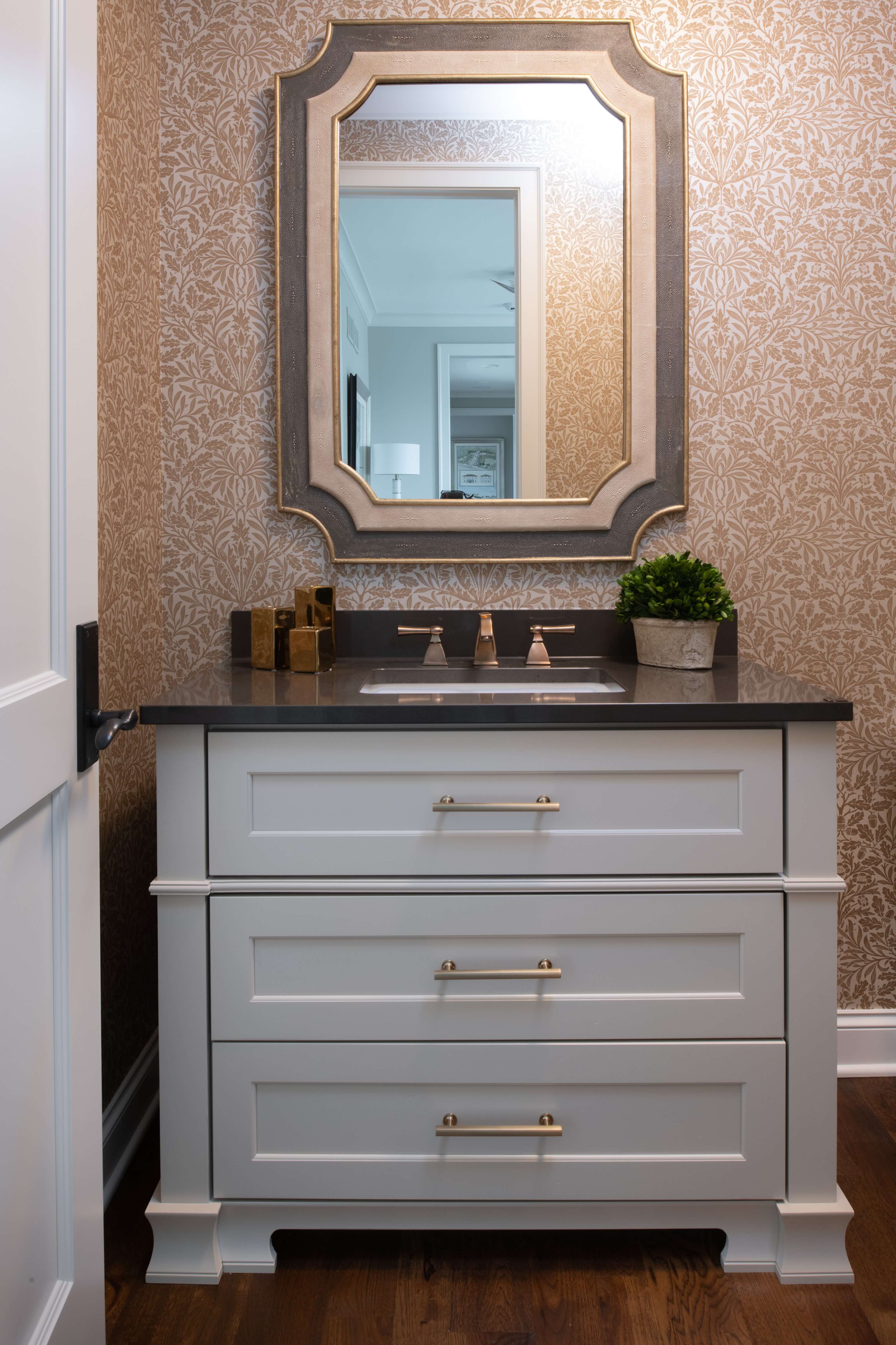 A furniture styled vanity with customized details, molding, and column ends that frame the cabinets.