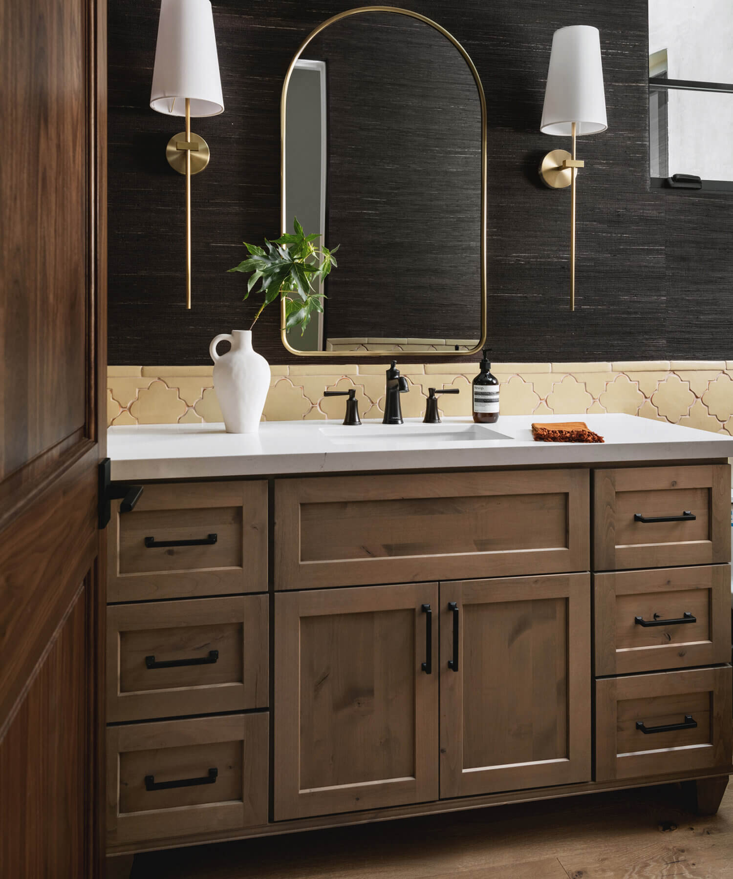 With an emphasis on comfort, heritage-inspired details, and lived-in textures, this master bathroom is a Mediterranean oasis. This stunning master suite features Dura Supreme’s Hudson shaker door style in the “Cashew” stain on Knotty Alder.