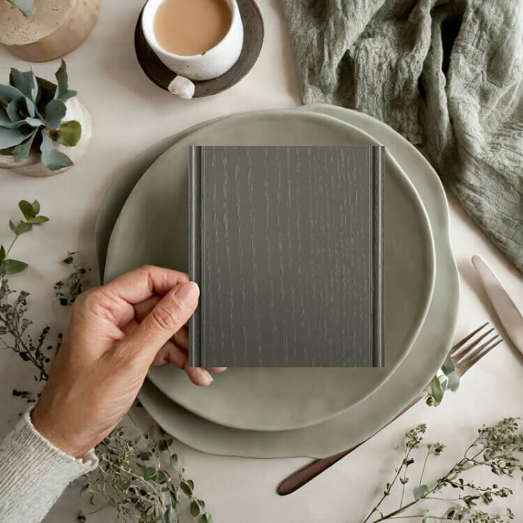 A close up of a cabinet sample of a trendy green painted oak finish showing the texture of the wood grain through the sleek layer of paint.