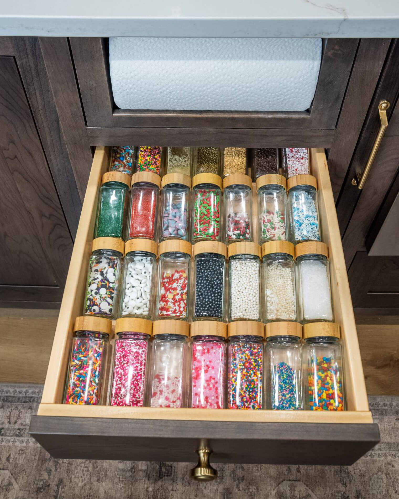 A kitchen drawer with an organized rack of sprinkles for the ultimate baker!