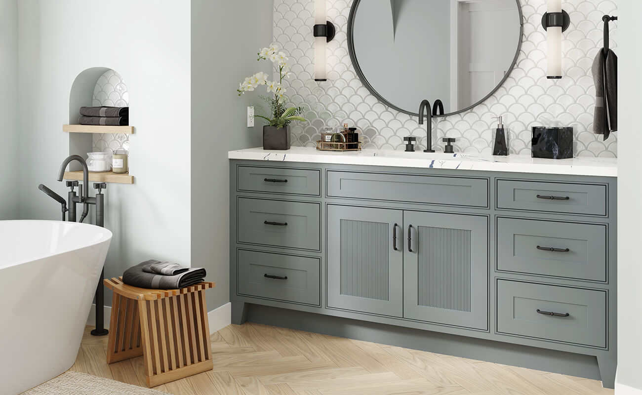 A furniture style bathroom vanity with reeded cabinet doors and a trendy light gray paint color.