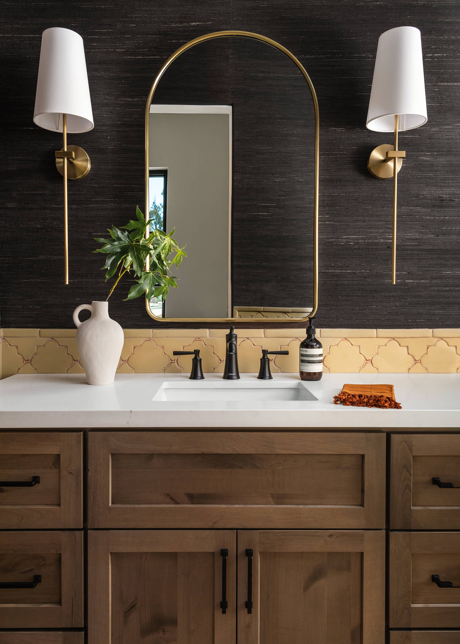 A moody bathroom with lots of organic texture, mixed metals, an earthy palette, and natural drama.